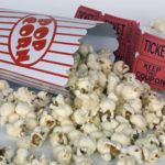 Pot de popcorn renversé avec tickets de cinéma en arrière plan